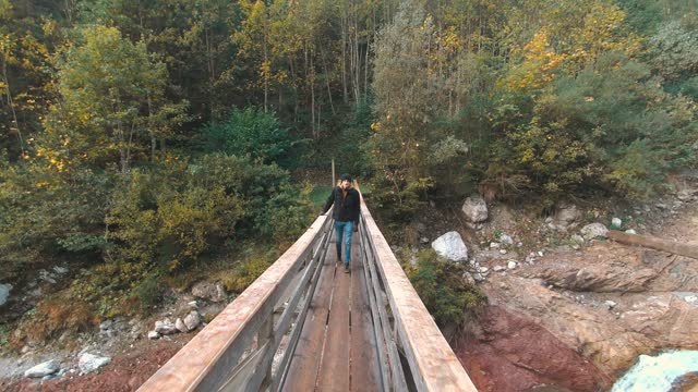 Carefree guy explore nature and hiking on mountains river bridge