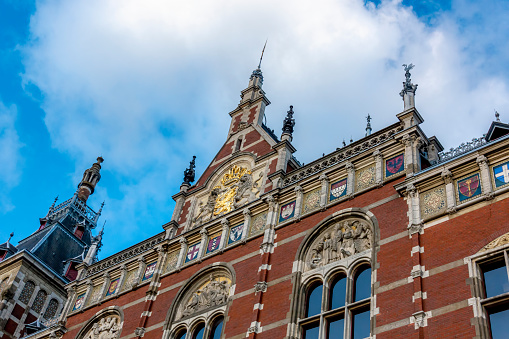 Amsterdam, Netherlands - Dec 1, 2019: Upper front facade of Amsterdam Centraal Station viewed from street level. A major European hub for public transport and tourism.