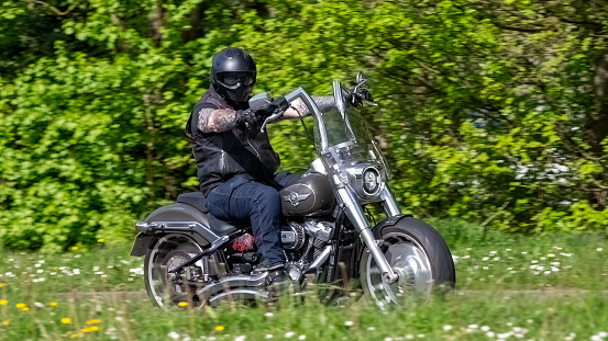 Milton Keynes,UK- Apr 14th 2024: Man riding a 2018 Harley Davidson flfbs Fatboy 114 motorcycle  on a British road