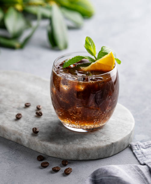 istock Coffee with tonic in a glass with mint, ice and lemon on a marble board on a light background 2148594332