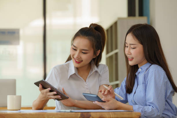 istock Two Asian businesswomen discuss new startup project idea presentation and analyze planning and financial statistics and investment market at the office. 2148595854