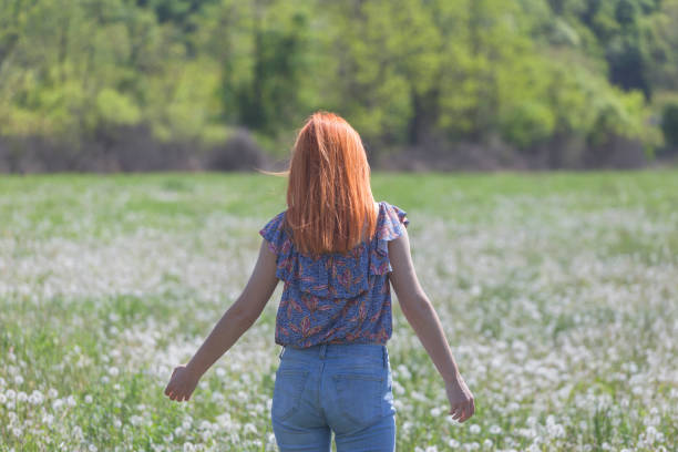 A Thai-Asian girl is happily walking in the middle of the grass.
