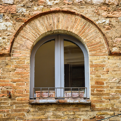 Old wooden window paved with bricks in a stone house in Spello, Umbria. A trip through the small towns of Italy