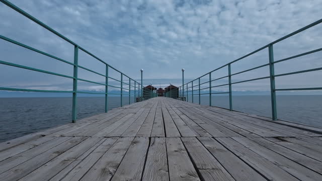 Beach pier on lake Issyk-Kul. Off-season. Cloudy and windy weather