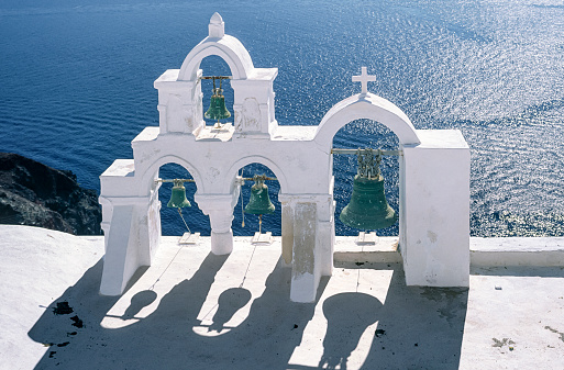 White-tinted belfry of a small chapel on the edge of the volcanic crater of San Turin, an island of the Greek Cyclades in the eastern Mediterranean