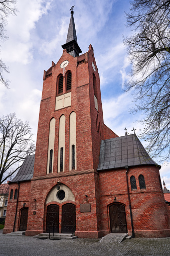 A historic, neo-Gothic Catholic church with a bell tower in the city of Poznan, Poland