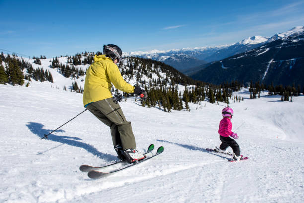 istock Family skis down slope at ski resort 2148601549