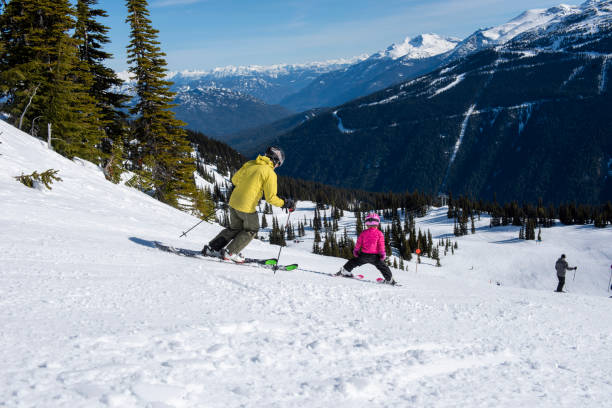 istock Family skis down slope at ski resort 2148601558