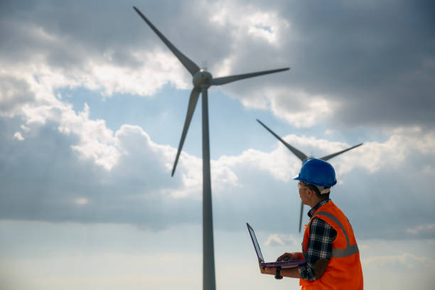 istock Young engineer man looking and checking wind turbines at field 2148602830