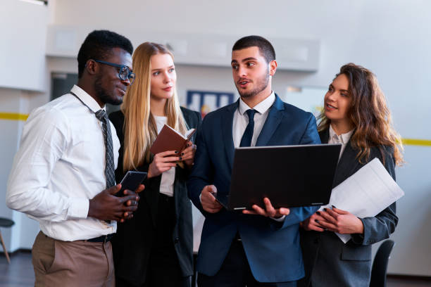 istock Multiethnic corporate team engage in project discussion. African, Caucasian, Arabic execs collaborate using tech. Woman, men analyze data in modern office setting, embodying teamwork, diversity. 2148603276