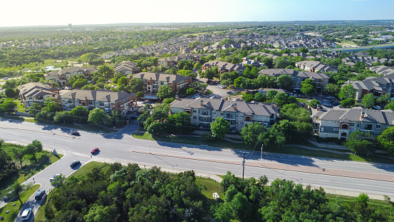 Suburban neighborhood with water tower, multistory apartment complex, single family houses, nature park busy car at entrance, lush green tree, Whippoorwill neighborhood, Cedar Park, Austin, Texas. USA