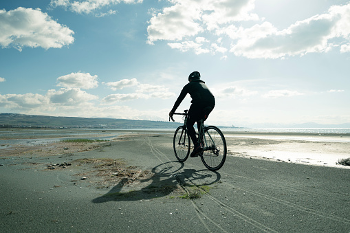 Professional cyclist cycling by the sea