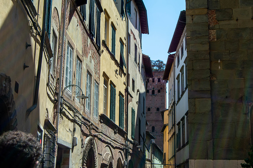 Guinigi tower from Via Sant'Andrea (saint Andrea street), typical Italian yellow buildings and sky