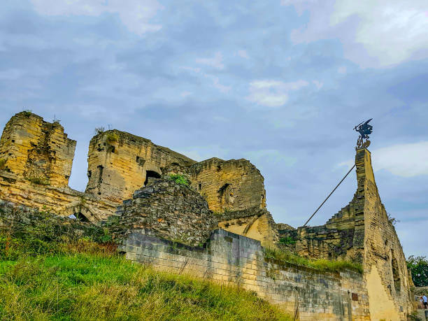 Ruined Valkenburg Castle on hill against cloud-covered blue sky, brick walls worn and destroyed by passage of time, sunny day in South Limburg in the Netherlands