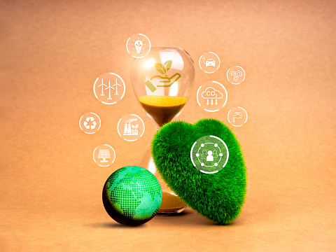 Green life sustainability, environment responsibility concept. Last chance for restoring the earth. Renewable icons on 3d earth globe, green grass heart shaped and hourglass on brown background.