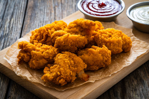 istock Fried chicken nuggets and ketchup on wooden background 2148610756