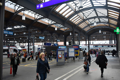 Basel, Switzerland - March 21, 2024: Station Basel SBB, Basel SBB Railway Station, Public Transportation Train, People Walking, Departing After Arrival With Train Scene And More