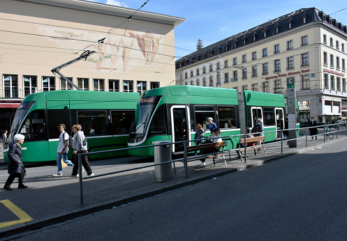 Basel, Switzerland - March 21, 2024: Basel Public Transportation Tram, Building Exterior, People Waiting For Tram, Departing After Arrival With Tram Scene And More During Springtime