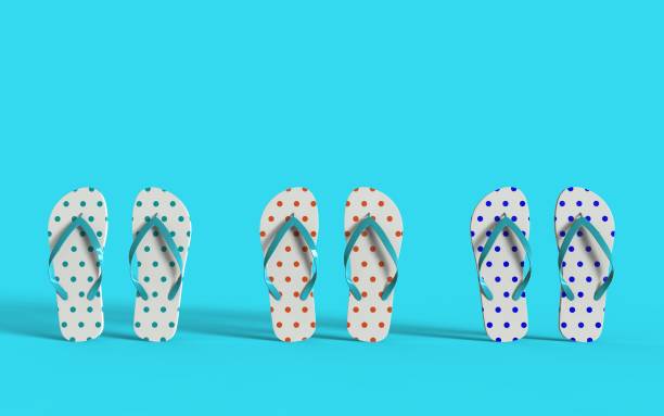 White flip flops with polka dots and blue stripes on the blue background