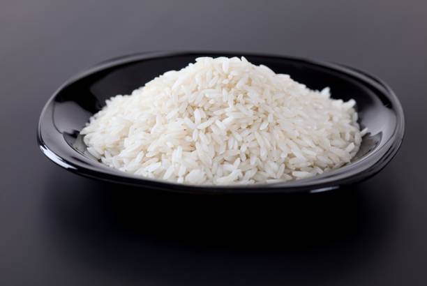 istock A black plate with white rice on a black background 2148611995