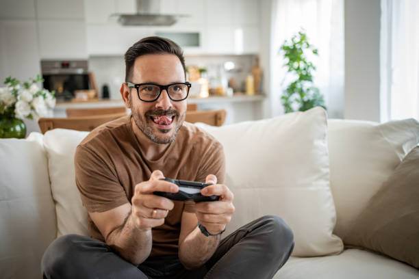 istock Smiling middle-aged man playing video games 2148613447