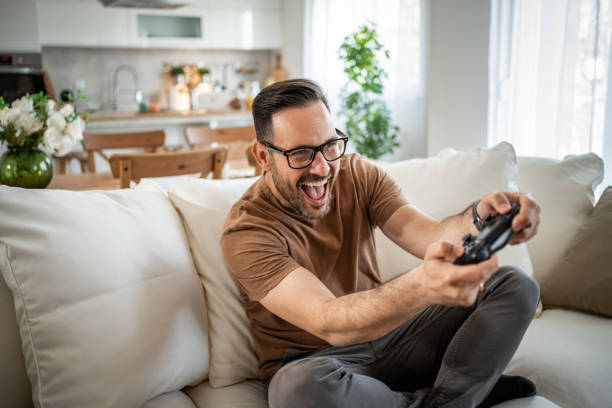 istock Smiling middle-aged man playing video games 2148613517