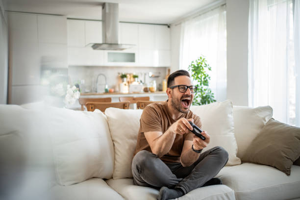 istock Smiling middle-aged man playing video games 2148613612