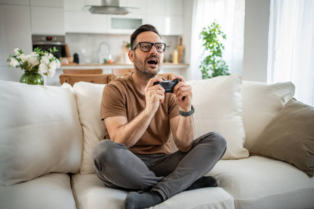 istock Smiling middle-aged man playing video games 2148613657