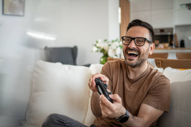 istock Smiling middle-aged man playing video games 2148613685