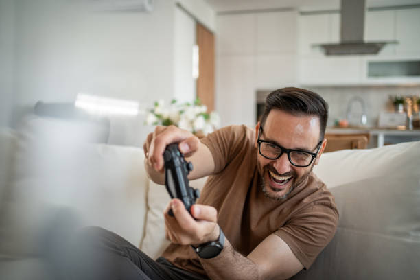 istock Smiling middle-aged man playing video games 2148613728