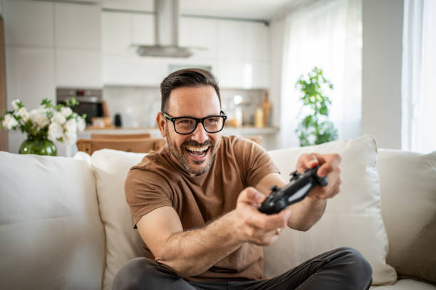 istock Smiling middle-aged man playing video games 2148613767