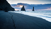 Black Beach, Iceland, in the morning, with footsteps on the black sand
