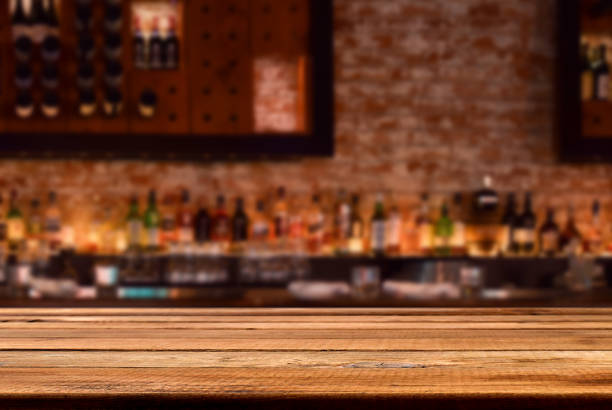istock Empty wooden bar counter with defocused brick wall with liquor bottles 2148614618