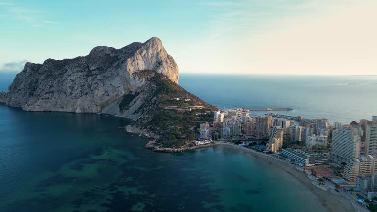 Cinematic aerial view of Calp city. Drone slowly track right above the bay. Fossa Beach and Ifac Mountain.
