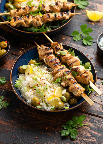 Greek grilled chicken skewers served with lemon rice and marinated green olives.