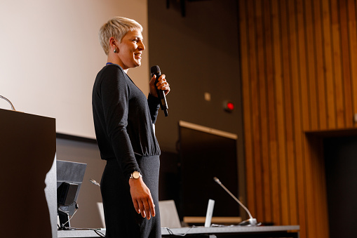 A woman giving a speech at a business technology conference.