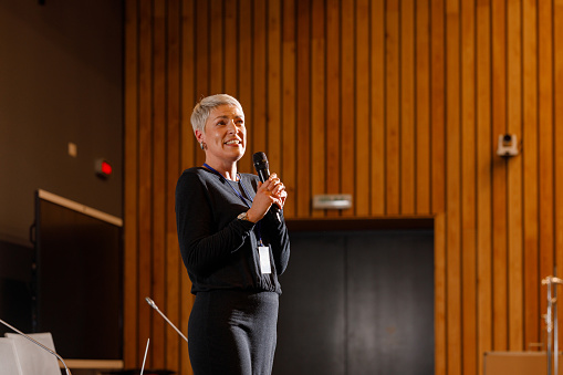 A woman giving a speech at a business technology conference.