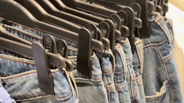 Sale assortment denim collection stand in boutique shop 4k stock video