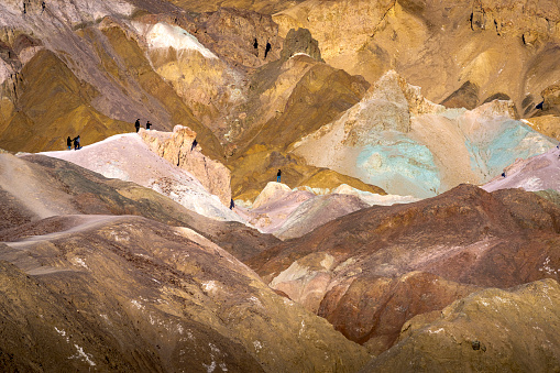 Hikers on the slopes of the Artists Palette in Death Valley National Park in California, United States