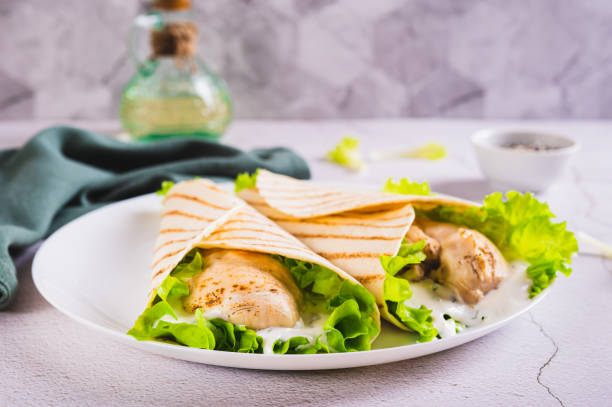 Dietary grilled tacos with chicken fillet, lettuce on a plate on the table