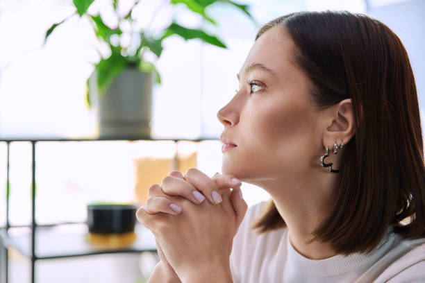 istock Excited sad upset young woman with folded hands, face in profile close-up 2148617873