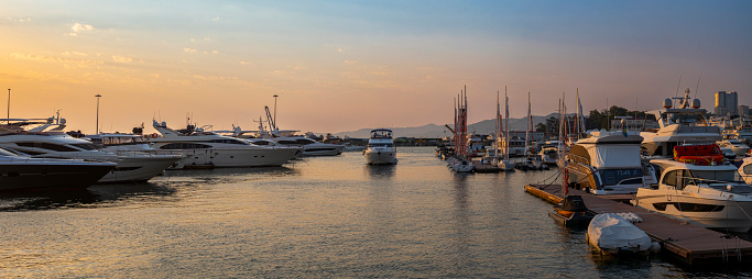 SOCHI, RUSSIA - August 10, 2023: yachts at the pier in the bay of the seaport at sunset