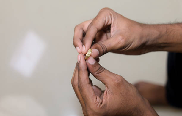 istock Close-up of a men holding a gold wedding ring with copy space 2148620018