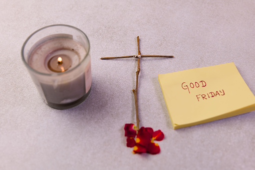 A cluster of yellow sticky notes on a white background, featuring the text Good Friday alongside a simple drawing of a cross and a burning candle