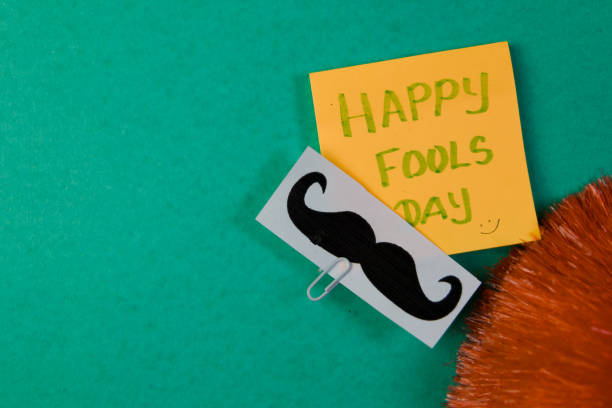 istock Happy Fools Day with mustache and greeting card on green background 2148620924