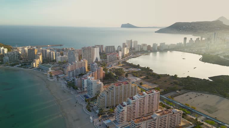 Panoramic aerial view of Calpe city. Drone panning right. View of Ifach Mountain and Salines de Calp Lacke.