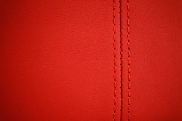 Red thread close-up on a blurred background of red leather car seat.