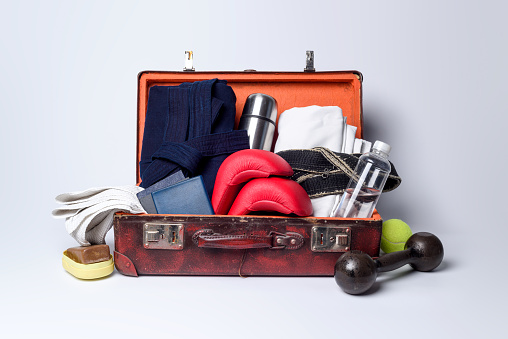 A suitcase full of things for martial arts on a light background.