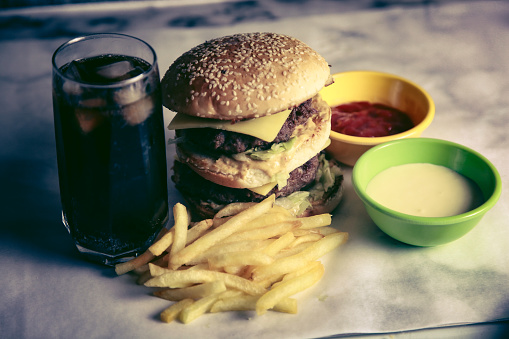 The amazing photo of homemade burger with cheese and fries with two sauces