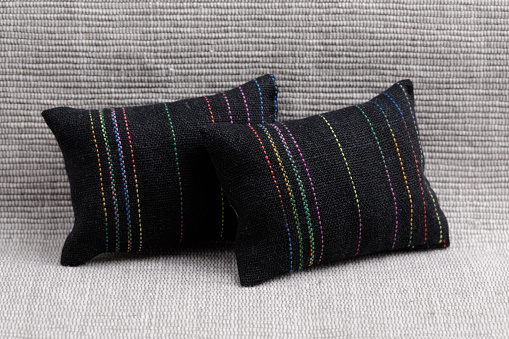 Black cushions with  stripes on a gray sofa